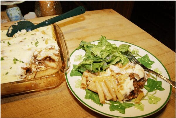 Baked pasta with melted cheese and salad
