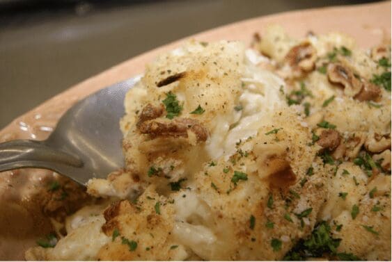 Cheesy baked cauliflower topped with walnuts