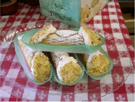 Pistachio-topped cannoli with powdered sugar