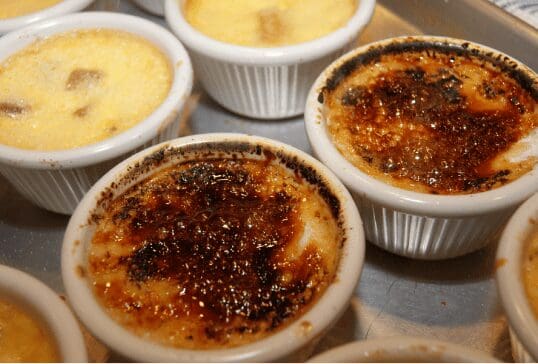 Caramelized crème brûlée in white ramekins