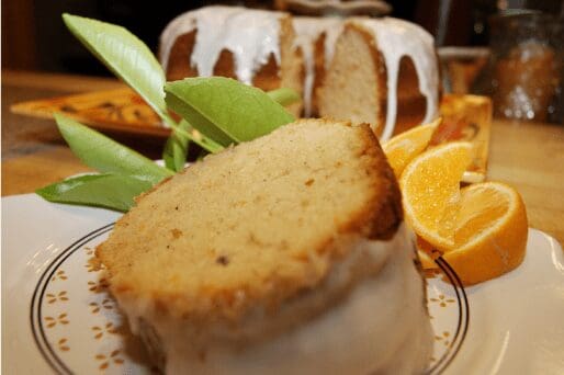 Glazed citrus pound cake slice with orange wedges