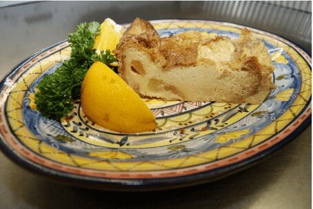 Slice of bread pudding with lemon wedge