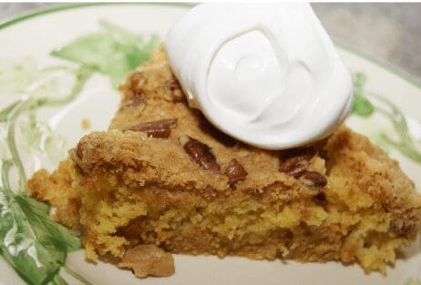 Slice of pecan coffee cake with whipped cream