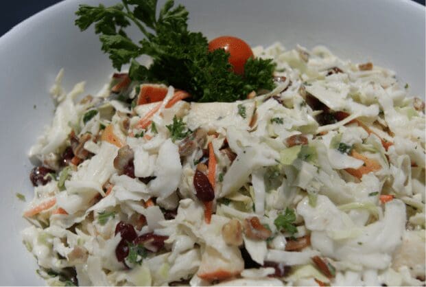 Bowl of creamy coleslaw with parsley garnish