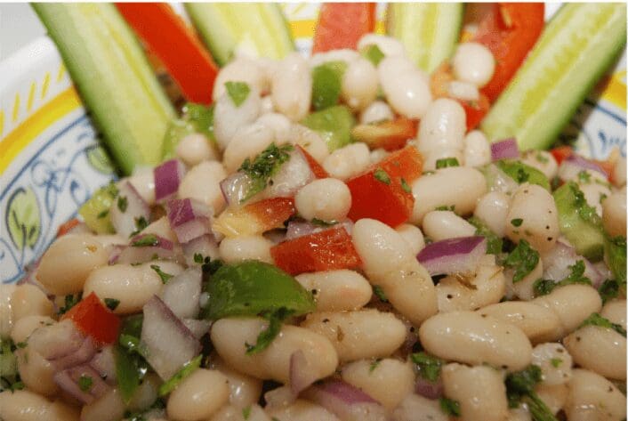 White bean salad with vegetables on plate.