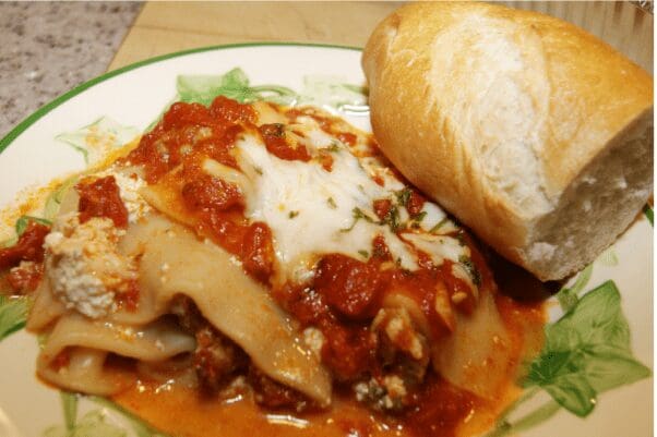 Hearty lasagna slice with crusty bread roll