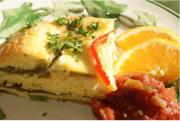 Cheesy frittata slice with salsa and orange